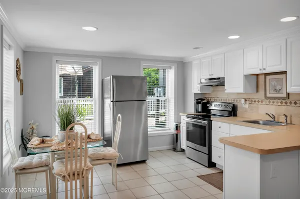 a kitchen with stainless steel appliances a stove a sink cabinets and a refrigerator