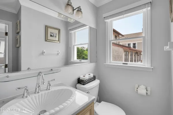 a bathroom with a granite countertop sink a toilet and a mirror