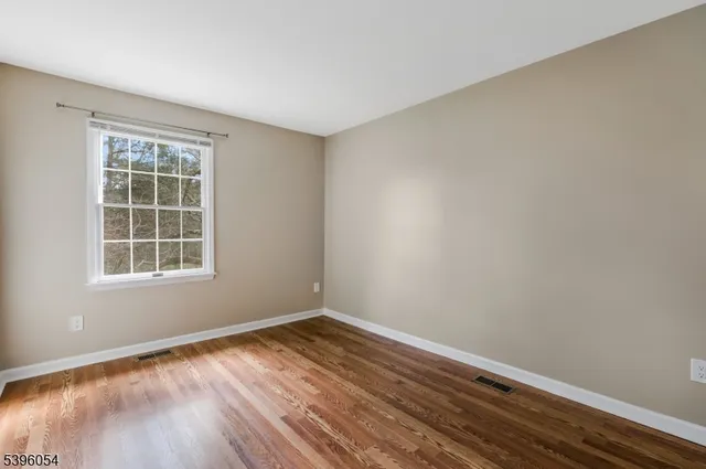 a view of a room with wooden floor and windows in it