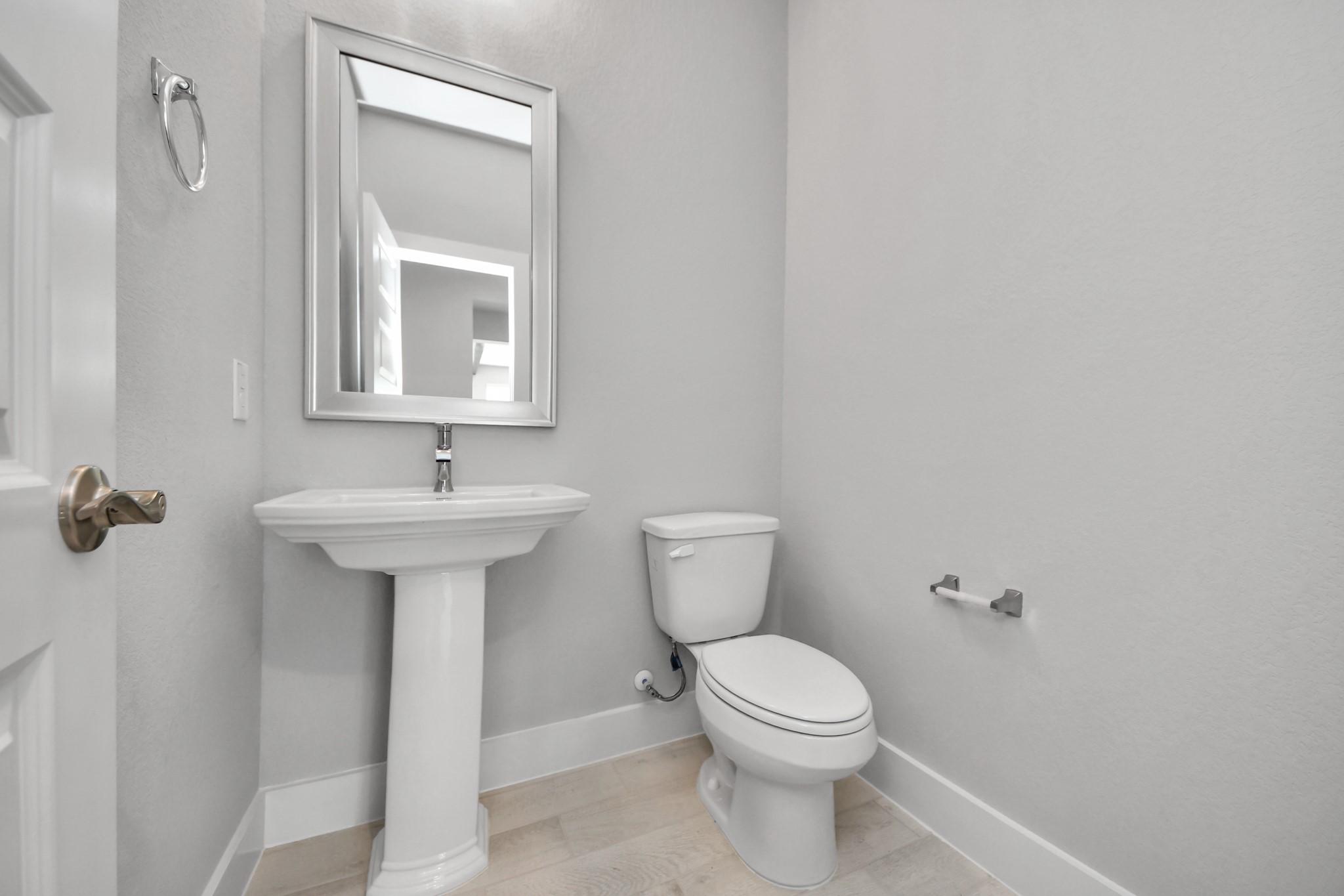3109 North Spring Drive Spring, TX 77373 - Photo 12 of 50 This half bathroom features a stylish pedestal sink, modern hardware, and bright recessed lighting, creating a sleek and inviting space.