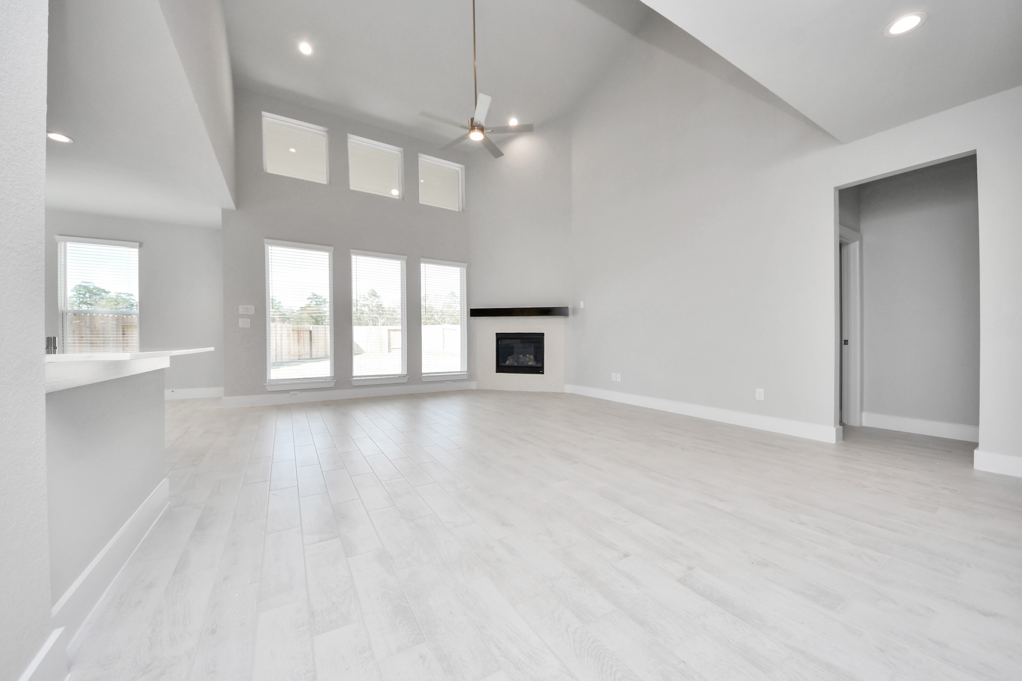 3109 North Spring Drive Spring, TX 77373 - Photo 23 of 50 Relax and unwind in this inviting family room, illuminated by abundant natural light streaming in through tall windows, complemented by high ceilings and stunning flooring. Stay comfortable year-round with the gentle breeze from the ceiling fan, creating the perfect atmosphere for family gatherings.