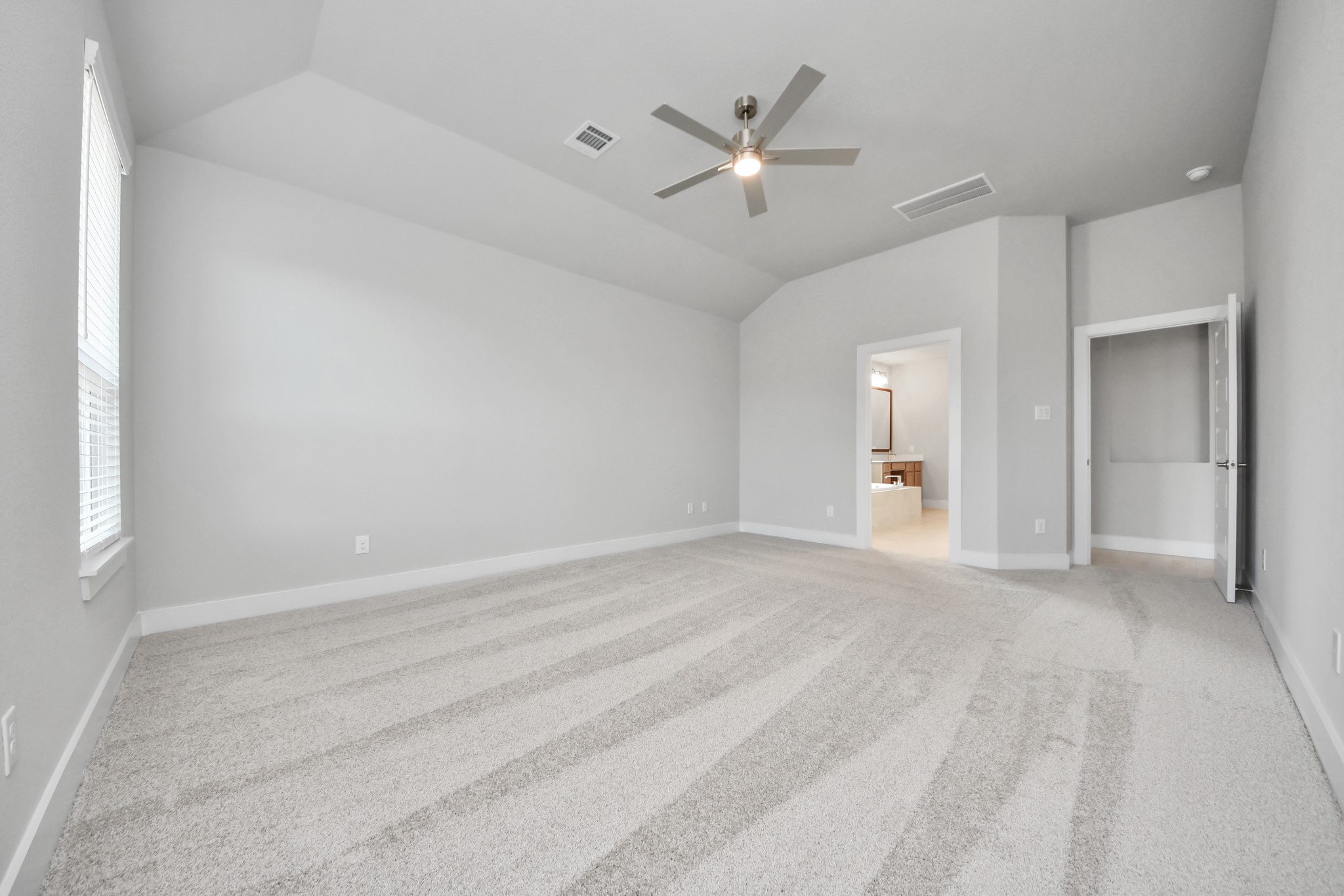 3109 North Spring Drive Spring, TX 77373 - Photo 24 of 50 Escape and relax in the exquisite primary suite, a haven to unwind after a long day. The spacious room, located on first floor, boasts plush carpeting, soothing paint tones, high ceilings, and expansive windows adorned with privacy blinds.