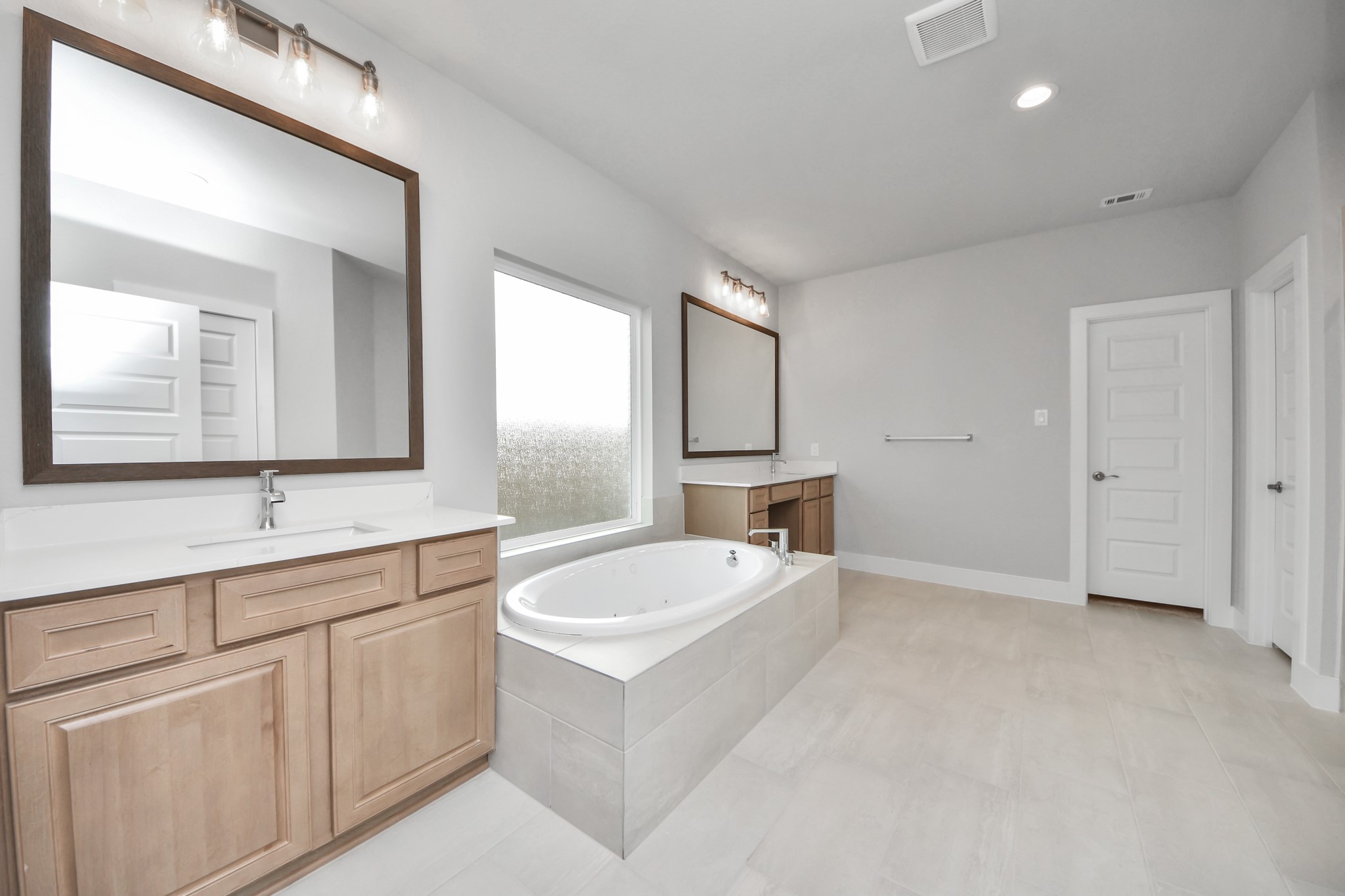 3109 North Spring Drive Spring, TX 77373 - Photo 26 of 50 Elevate your daily routine at the elegant vanity, now equipped with double sinks, light countertops, modern hardware, and beautiful vanity lights.