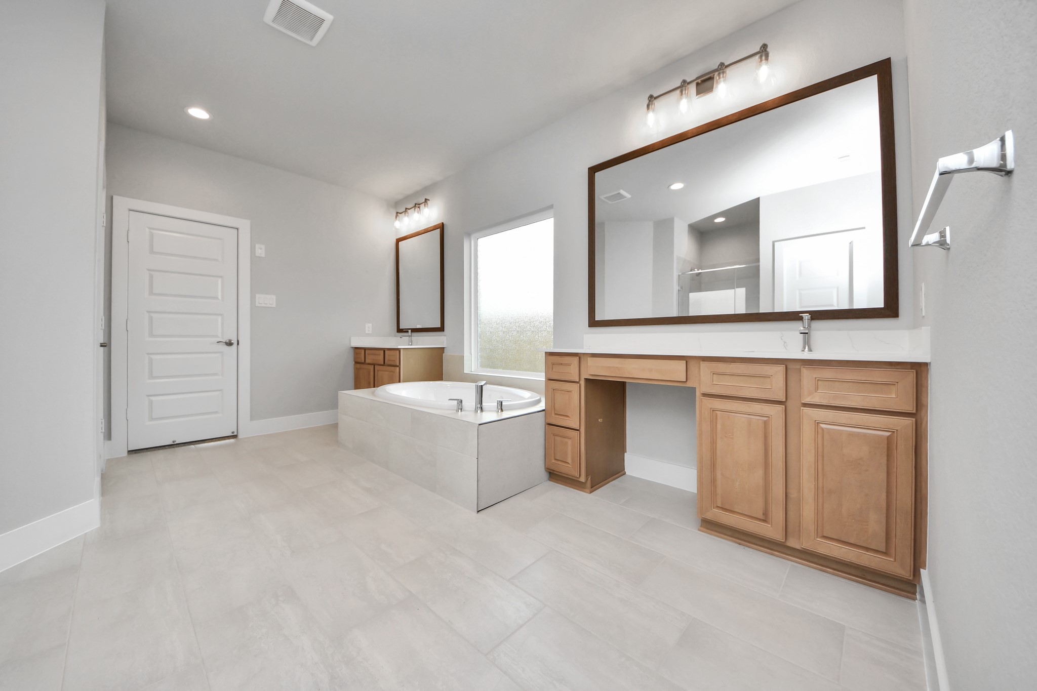 3109 North Spring Drive Spring, TX 77373 - Photo 27 of 50 Indulge in a spa-like retreat within the confines of this primary bathroom. Delight in a spacious walk-in shower enveloped in stylish tile surround, unwind in a separate garden tub adorned with custom detailing.