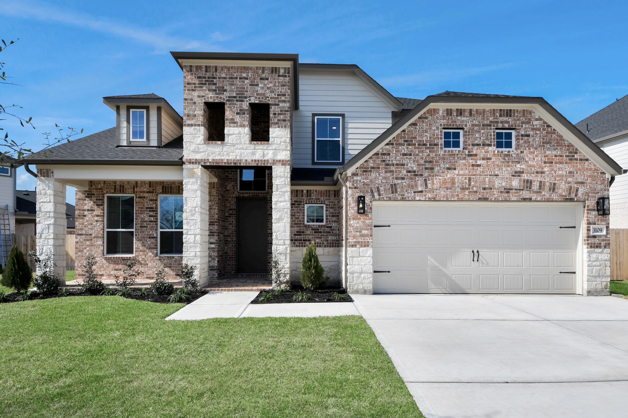 3109 North Spring Drive Spring, TX 77373 - Photo 3 of 50 This home boasts lush green grass and meticulous landscaping. Its premium elevation showcases an exquisite blend of brick and stone features, complemented by modern coach lighting