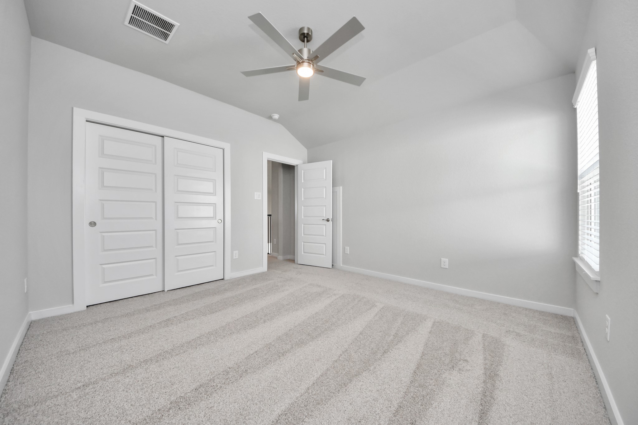 3109 North Spring Drive Spring, TX 77373 - Photo 42 of 50 Secondary bedroom features plush carpeting, large windows that let in plenty of natural light, bright paint, and spacious closets.