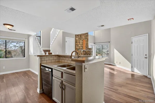 a kitchen with a stove and wooden floor