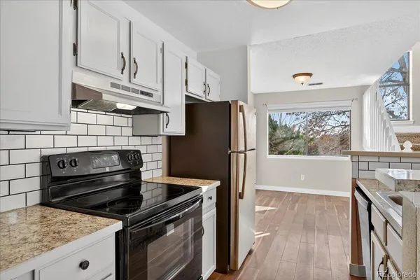 a kitchen with stainless steel appliances granite countertop a stove a refrigerator and a cabinets