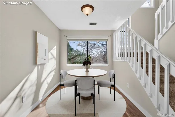 a dining room with furniture a rug and a large window