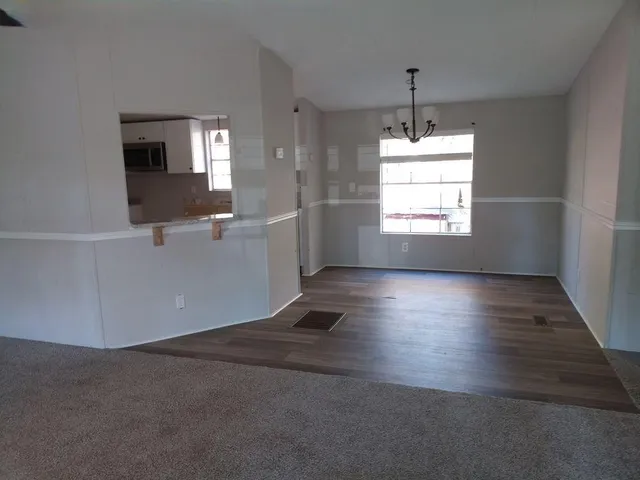 a view of a livingroom with wooden floor and a window