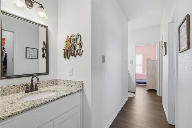 a en suite bathroom with a granite countertop sink and a mirror