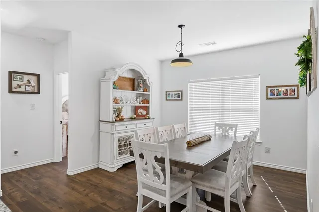 a kitchen with stainless steel appliances granite countertop a stove a kitchen island a dining table and chairs with wooden floor