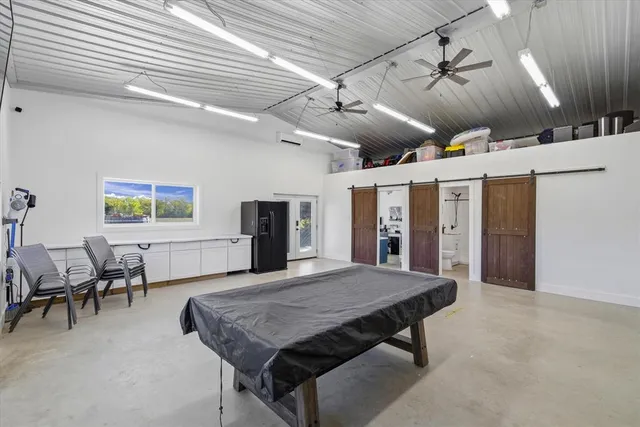 a room with furniture pool table flat screen tv and couches