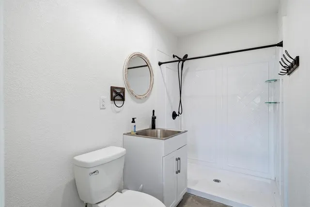 a bathroom with a sink a toilet and shower