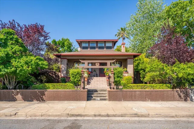 a front view of a house with a garden