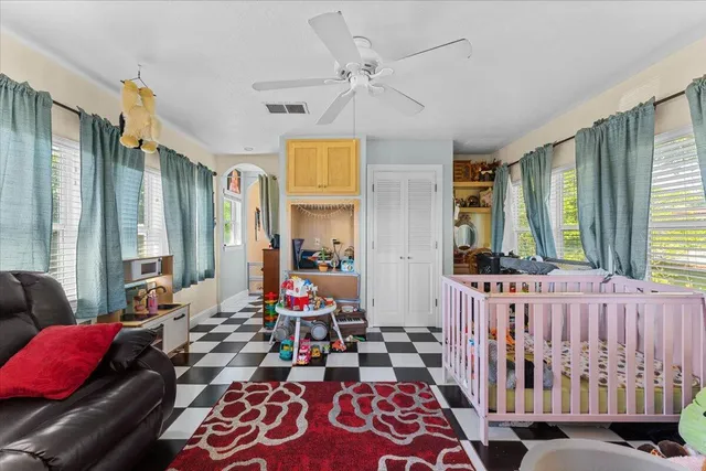 a kitchen with stainless steel appliances a sink a stove a chimney a large window and cabinets