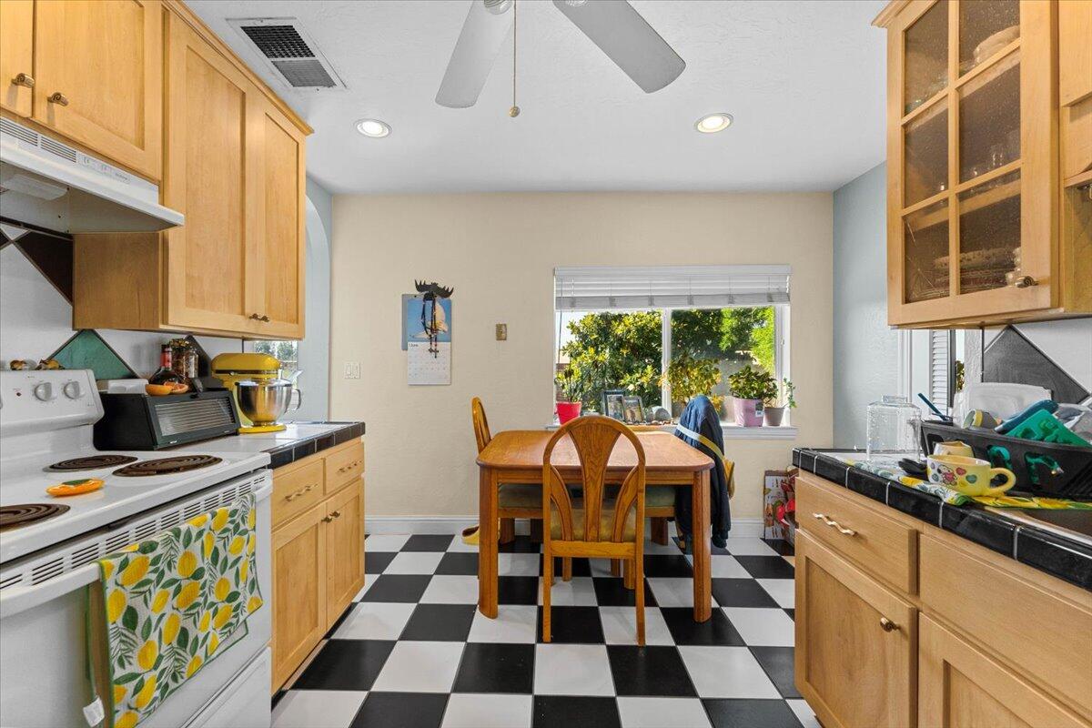 931 Rio Street Red Bluff, CA 96080 - Photo 30 of 54 a kitchen with stainless steel appliances a sink a stove a chimney a large window and cabinets