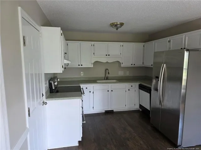 a kitchen with stainless steel appliances a refrigerator sink and cabinets