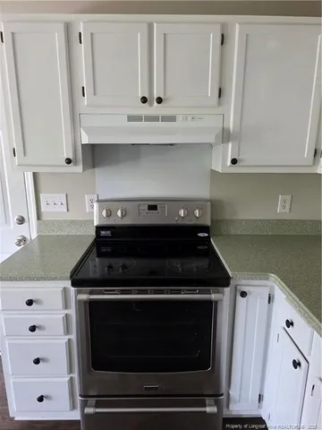 a stove top oven sitting inside of a kitchen