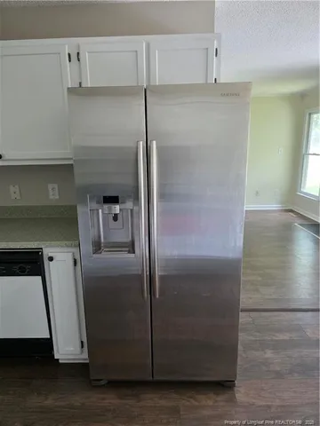 a metallic refrigerator freezer sitting in a kitchen