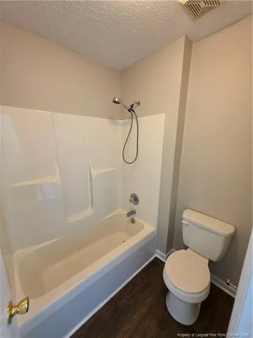 a bathroom with a granite countertop toilet a sink and bathtub