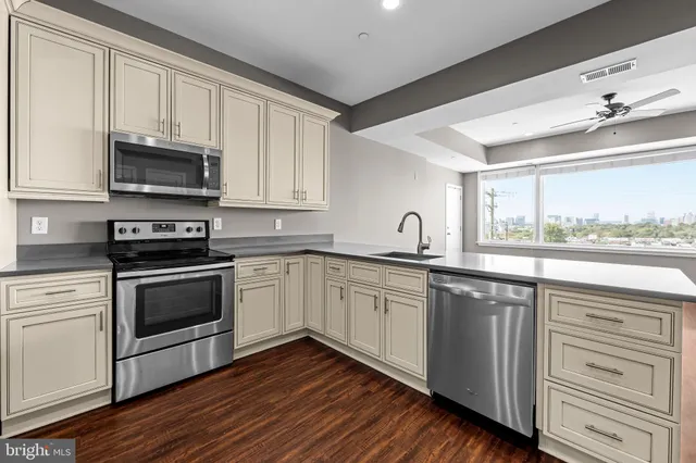 a kitchen with granite countertop cabinets stainless steel appliances and a window