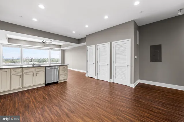 a large kitchen with a wooden floor and windows