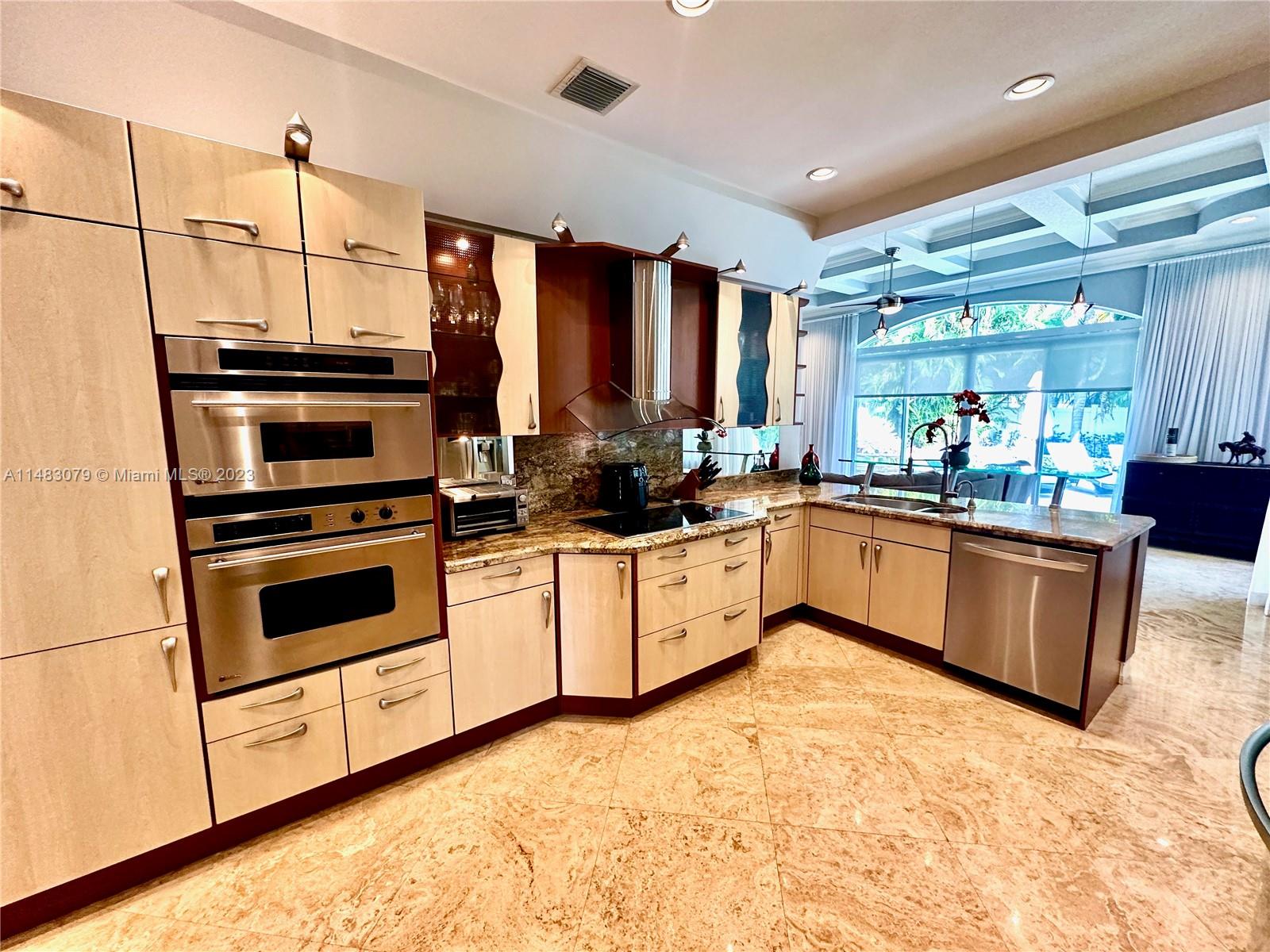 465 Northeast 2nd Street Boca Raton, FL 33432 - Photo 16 of 73 a kitchen with stainless steel appliances kitchen island granite countertop a stove a sink and a refrigerator