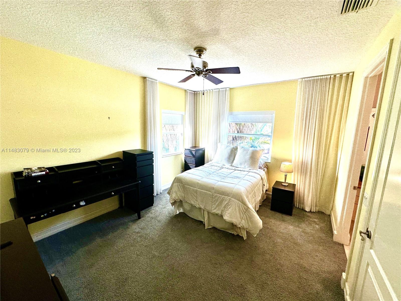 465 Northeast 2nd Street Boca Raton, FL 33432 - Photo 57 of 73 a spacious bedroom with a bed and a chandelier
