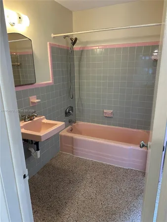 a bathroom with a sink a bathtub and shower
