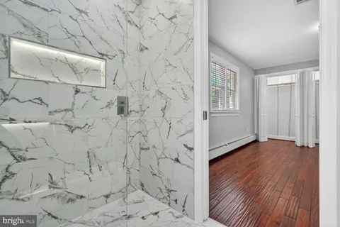 a bathroom with a bathtub shower sink vanity mirror and toilet