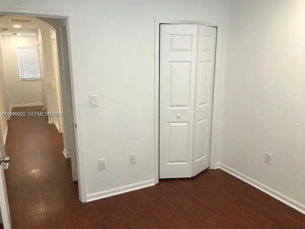 an empty room with wooden floor and closet