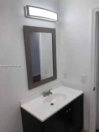 a bathroom with a sink vanity and a mirror