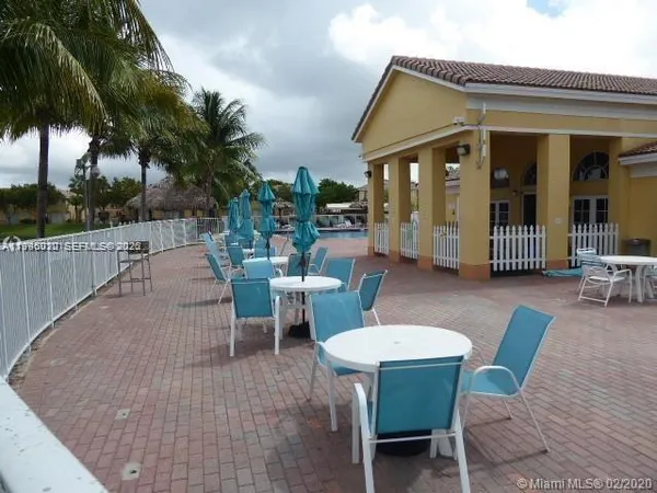 a view of a patio with couches table and chairs and potted plants
