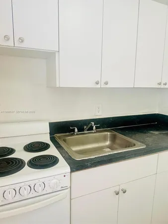 a kitchen with a stove and white cabinets