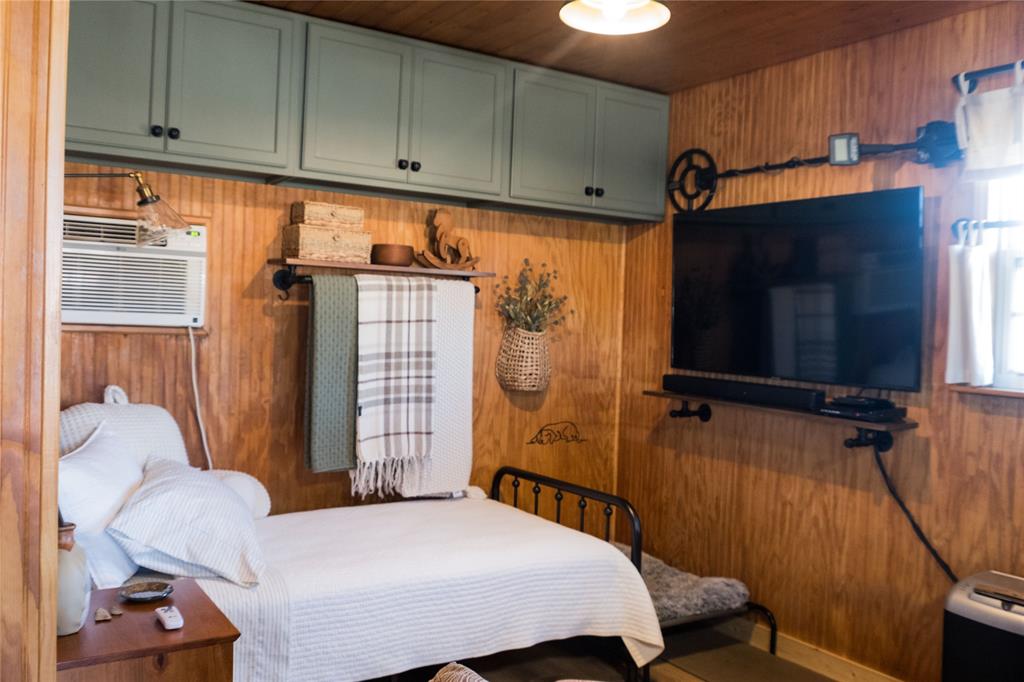 1597 County Road 305 Zephyr, TX 76890 - Photo 5 of 40 a bedroom with a bed a flat screen tv and cabinets