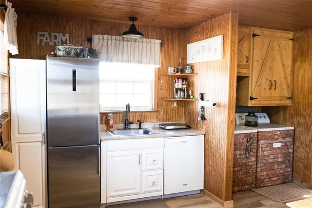 a kitchen with stainless steel appliances a refrigerator sink and cabinets