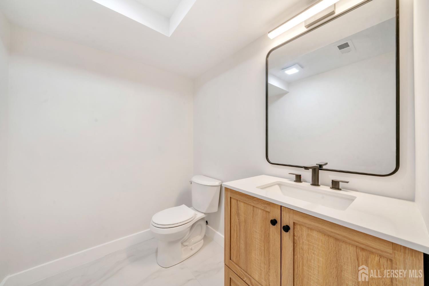 66 Garden Terrace Edison, NJ 08817 - Photo 38 of 40 a bathroom with a sink toilet and mirror