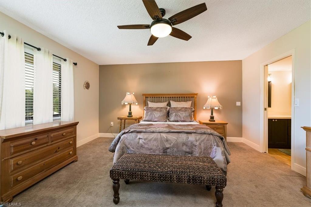 75 St Andrews Boulevard, Unit C301 Naples, FL 34113 - Photo 15 of 42 a bedroom with a bed and a chandelier