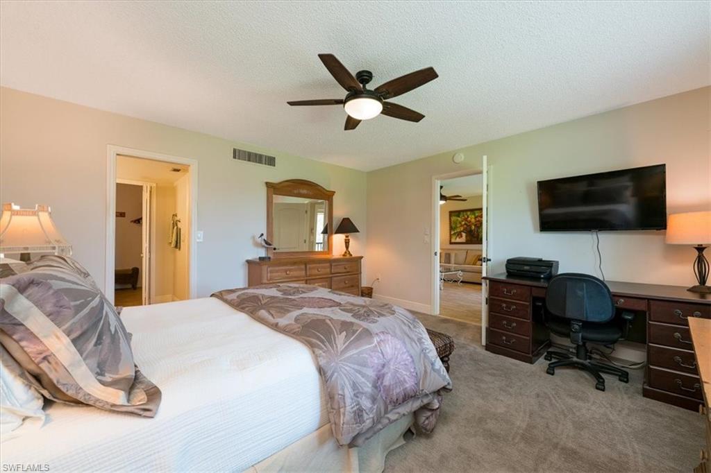 75 St Andrews Boulevard, Unit C301 Naples, FL 34113 - Photo 16 of 42 a bedroom with a bed and a desk