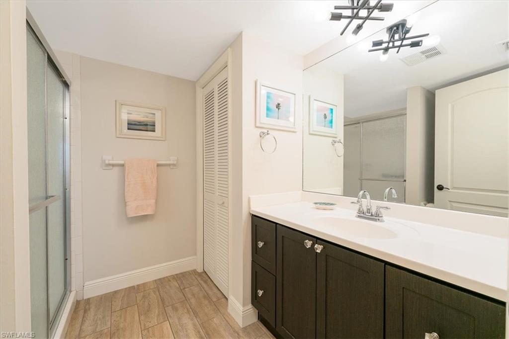 75 St Andrews Boulevard, Unit C301 Naples, FL 34113 - Photo 21 of 42 a bathroom with a double vanity sink and mirror