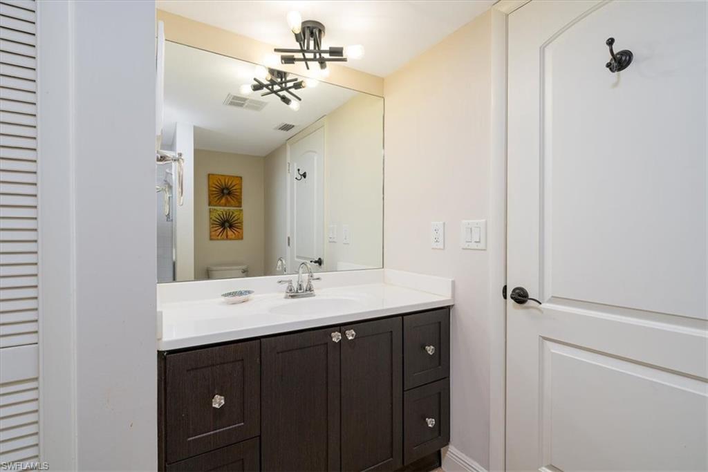 75 St Andrews Boulevard, Unit C301 Naples, FL 34113 - Photo 22 of 42 a bathroom with a sink vanity and mirror