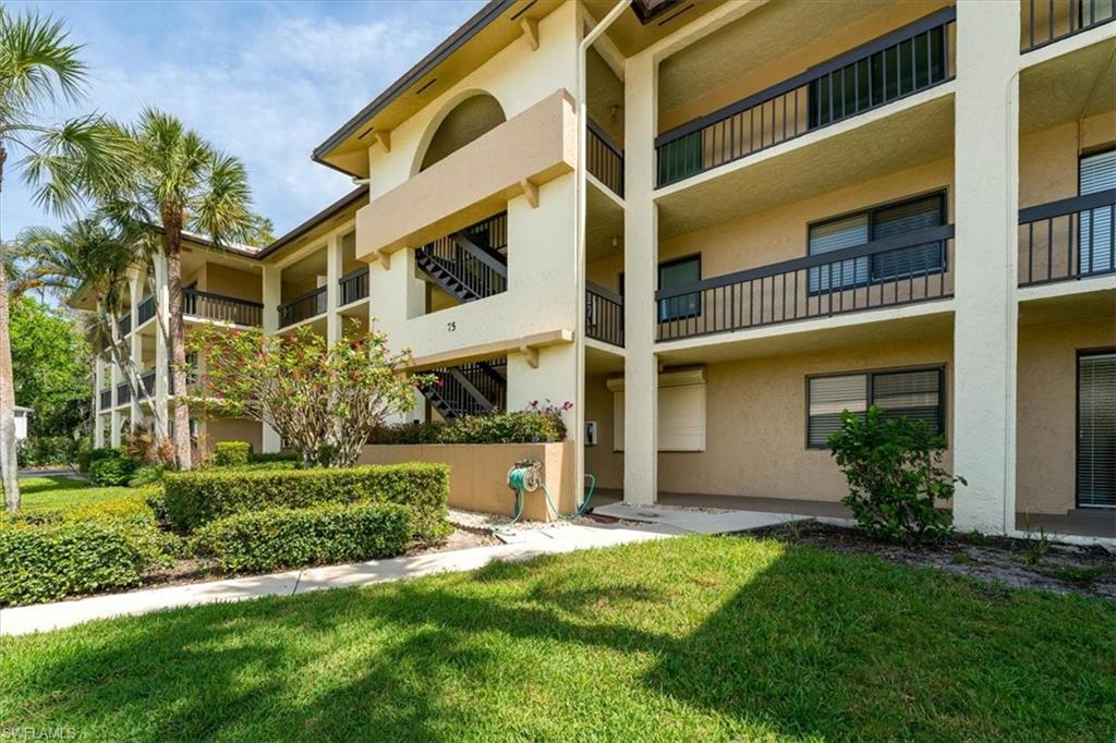 75 St Andrews Boulevard, Unit C301 Naples, FL 34113 - Photo 3 of 42 a front view of a residential apartment building with a yard