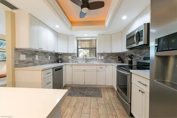 a kitchen with a sink stainless steel appliances and white cabinets