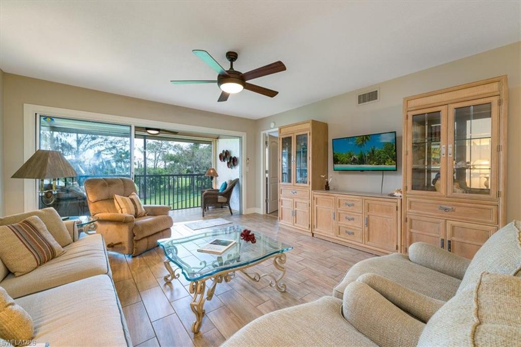 75 St Andrews Boulevard, Unit C301 Naples, FL 34113 - Photo 5 of 42 a living room with furniture and a large window