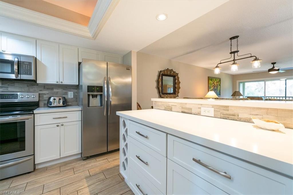 75 St Andrews Boulevard, Unit C301 Naples, FL 34113 - Photo 7 of 42 a kitchen with cabinets and stainless steel appliances