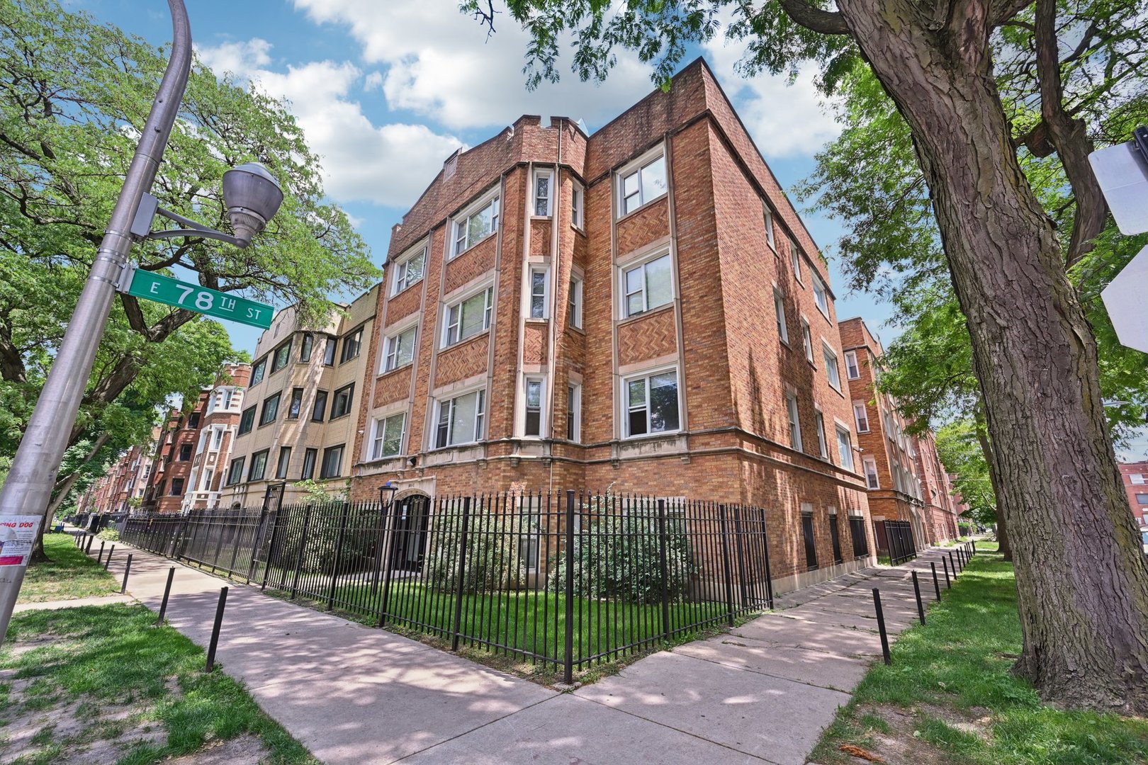 2506 East 78th Street, Unit 2 Chicago, IL 60649 - Photo 1 of 24 a view of a large white building next to a yard