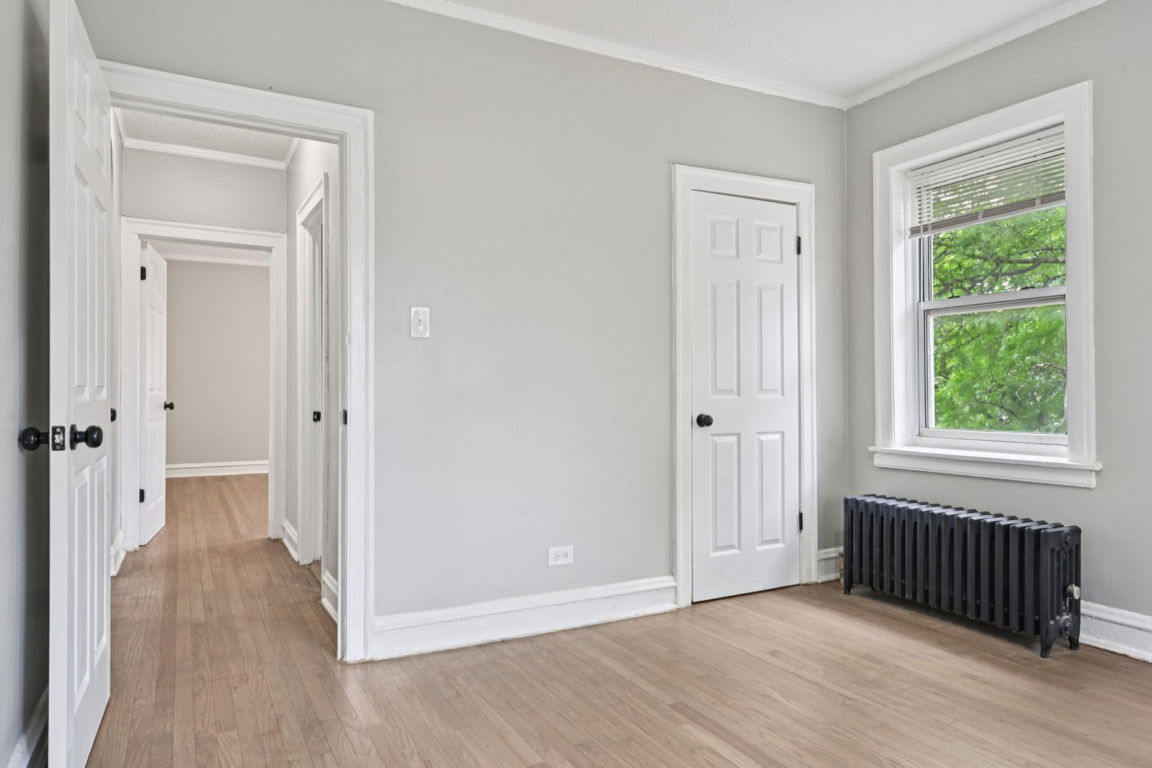 2506 East 78th Street, Unit 2 Chicago, IL 60649 - Photo 18 of 24 an empty room with wooden floor cabinet and windows