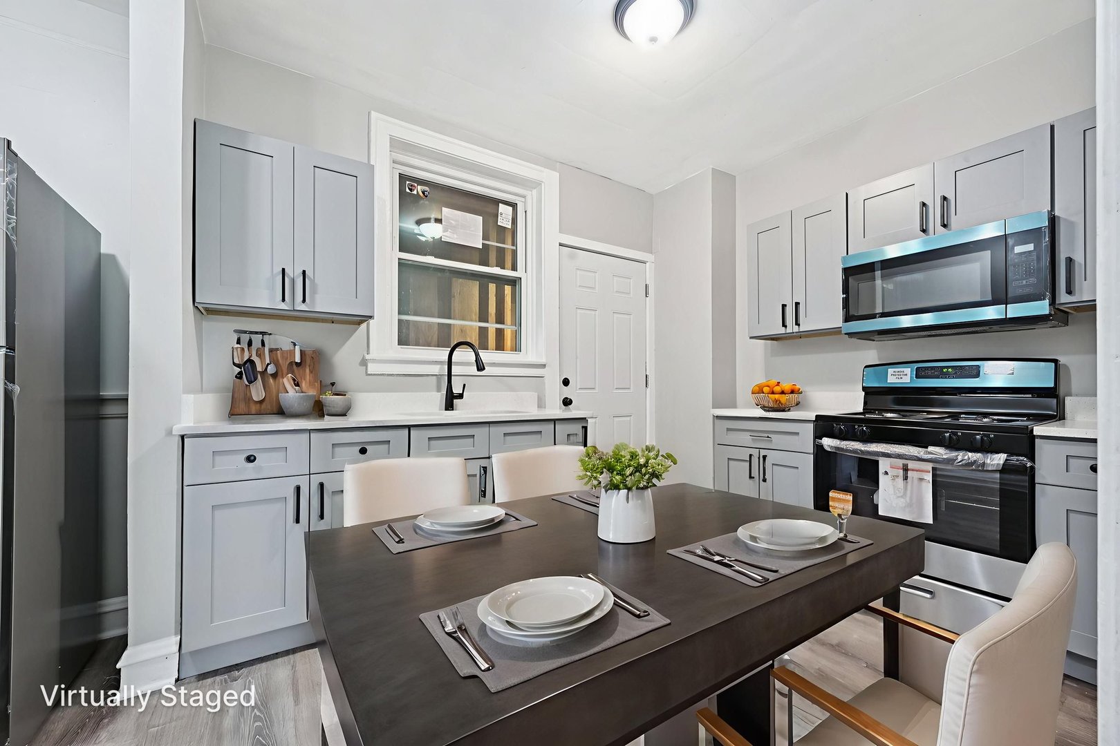 2506 East 78th Street, Unit 2 Chicago, IL 60649 - Photo 7 of 24 a kitchen with stainless steel appliances a dining table and chairs