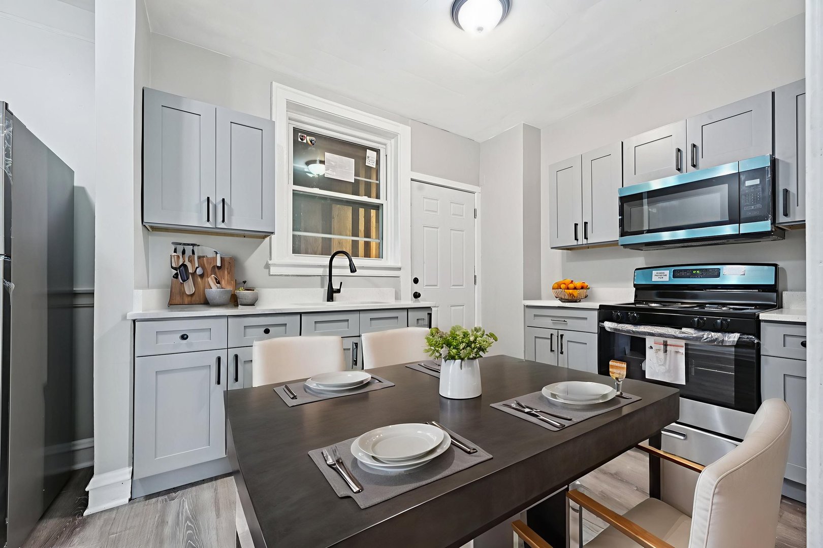 2506 East 78th Street, Unit 2 Chicago, IL 60649 - Photo 9 of 24 a kitchen with stainless steel appliances a dining table and chairs